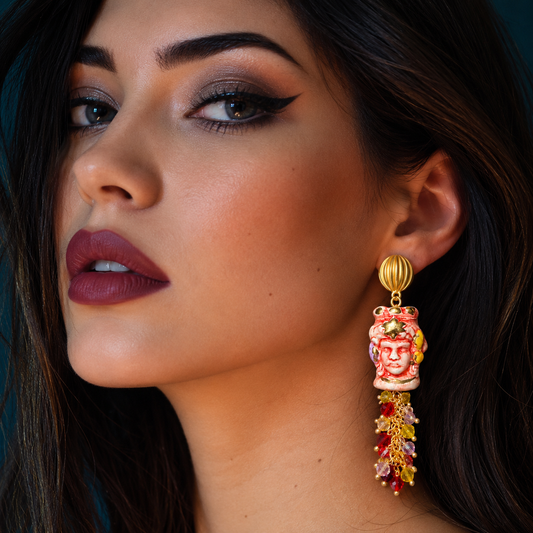 Model wearing handcrafted Caltagirone ceramic Moor’s Head earring in red and white with 10% gold lustre, Swarovski crystals and gold-tone details.