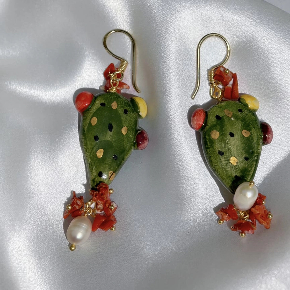 Front view of handmade Sicilian prickly pear earrings in green Caltagirone ceramic with red coral and freshwater pearls