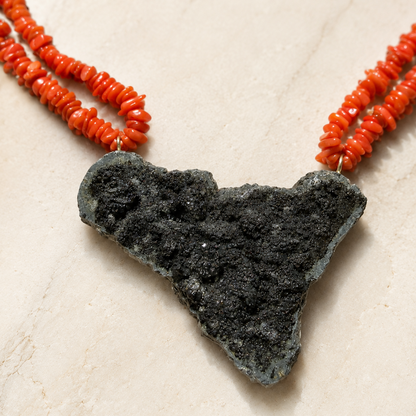 Close-up of Sicily-shaped Mount Etna lava stone pendant with Mediterranean red coral necklace