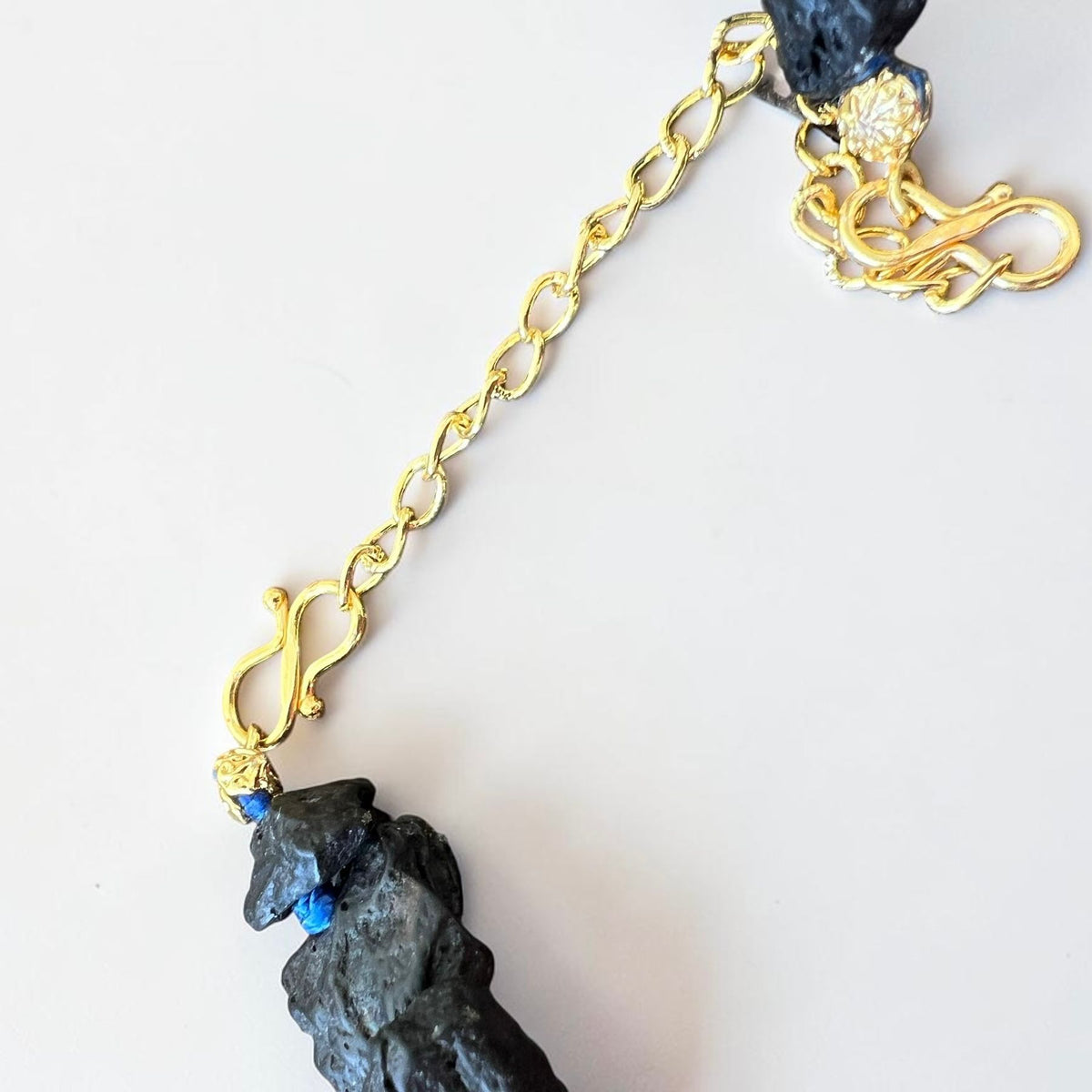 Gold-tone clasp and extension chain detail on handmade Sicilian Etna lava stone necklace