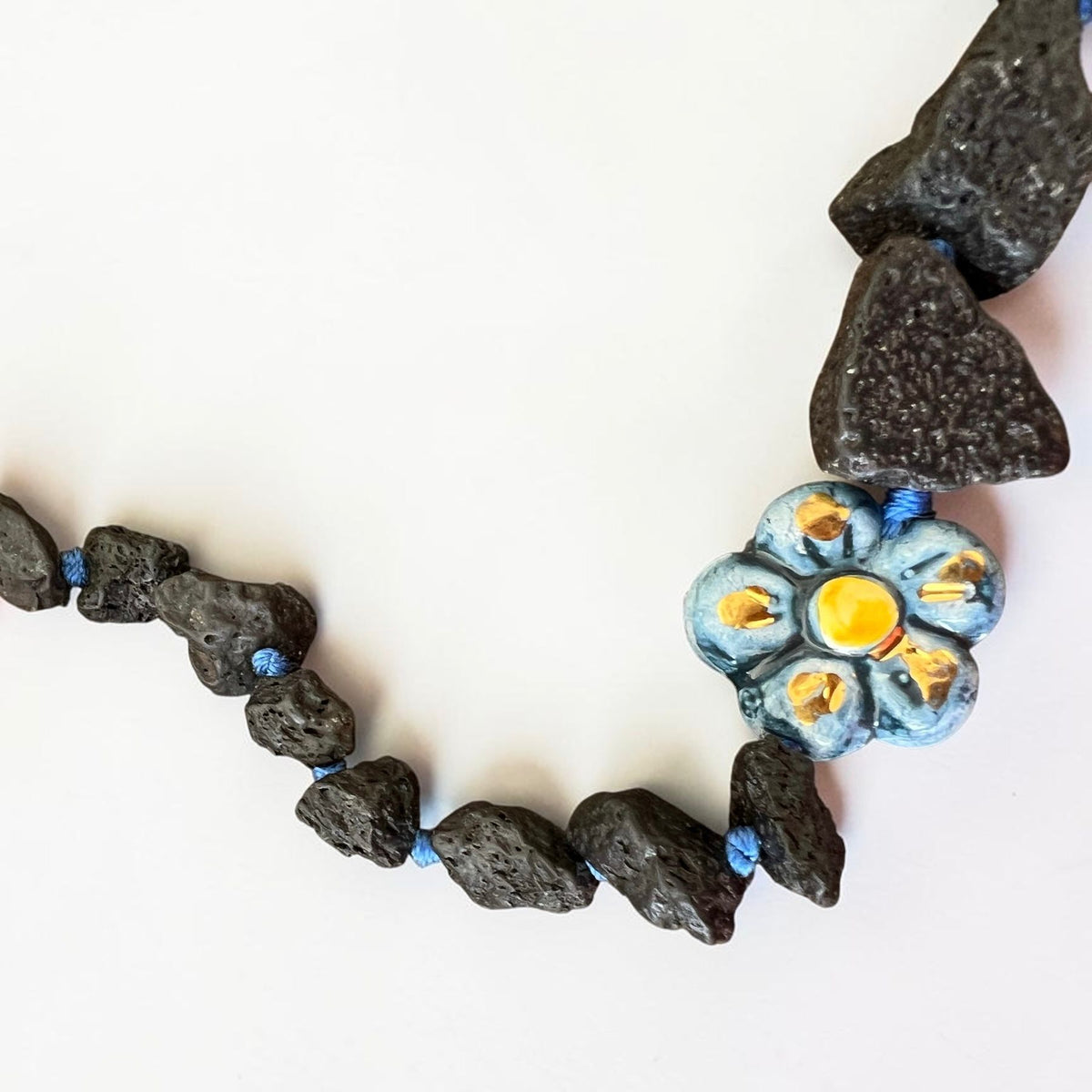 Natural black Etna lava stones with hand-painted Sicilian ceramic flower detail on artisan necklace