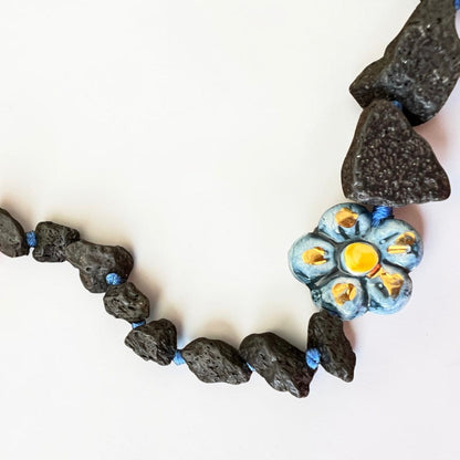 Natural black Etna lava stones with hand-painted Sicilian ceramic flower detail on artisan necklace