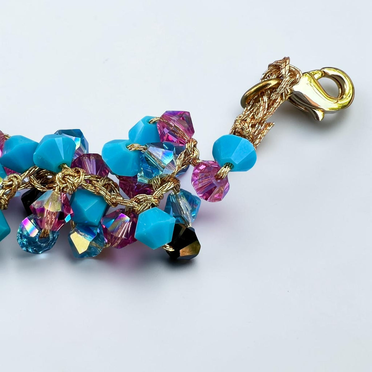 Close-up of gold-tone clasp and turquoise Swarovski crystal details on a handmade Sicilian bracelet