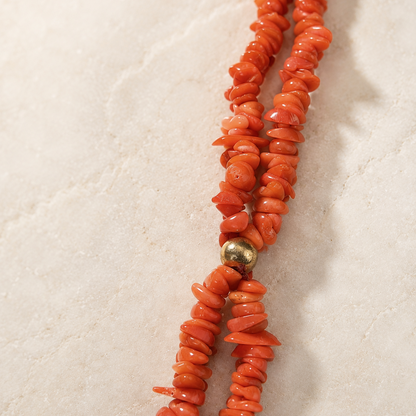 Close-up of Mediterranean red coral beads on handmade Sicilian necklace with gold-tone spacer detail