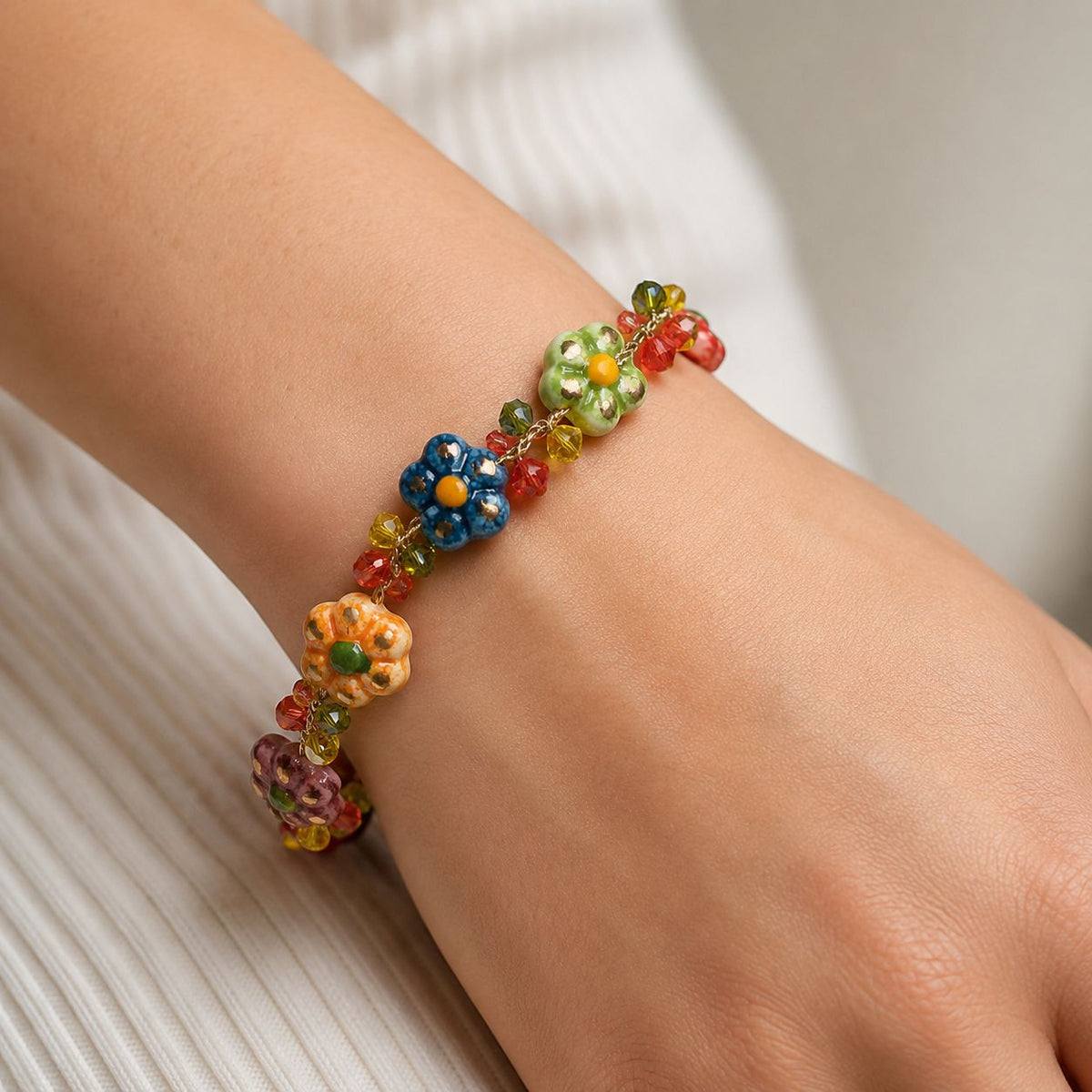 Woman wearing handmade Sicilian ceramic flower bracelet with colorful Caltagirone ceramic charms