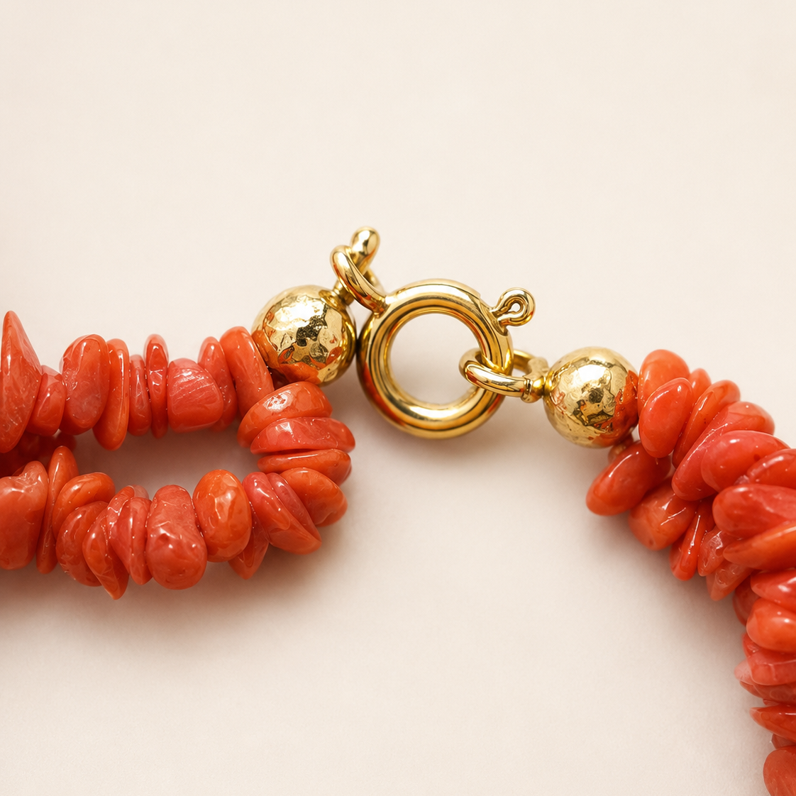 Close-up of gold-tone clasp and Mediterranean red coral beads on handmade Sicilian Etna Heart necklace