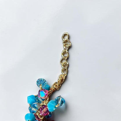 Close-up of gold-tone extension chain, crochet braid and turquoise Swarovski crystals on a handmade Sicilian bracelet
