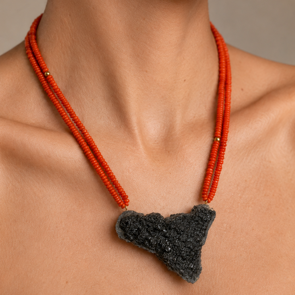 Woman wearing handmade Sicilian red coral necklace with Sicily-shaped Mount Etna lava stone pendant