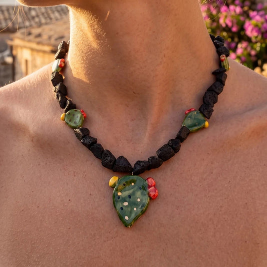 Woman wearing a handmade Sicilian necklace with Mount Etna lava stone and hand-painted Caltagirone ceramic prickly pear pendant